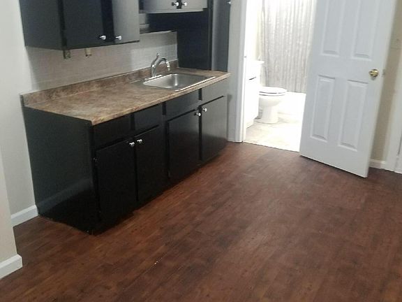 Open plan kitchen with richly stained cabinets.