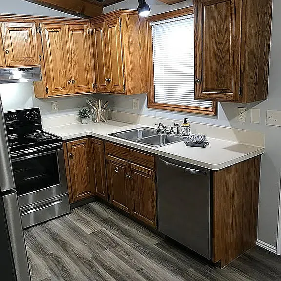 Kitchen with electric stove, refrigerator, and dishwasher.