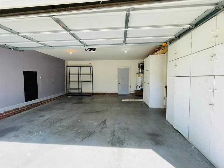 Two car garage with shelves and many cabinets for tools