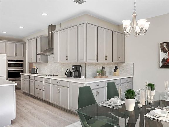 Virtually staged kitchen that features a cook top, built in oven and dining area