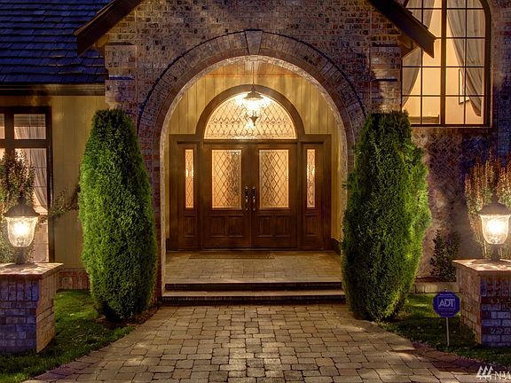 Spectacular new paver stone circular drive and all new landscaping set the stage for a grand entrance. The covered cedar tongue and grove lined entry boasts new custom heavy solid wood double doors with leaded glass insets, side and transom window with quality Baldwin chrome hardware. 