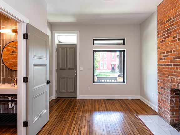 120 year-old refinished hardwood flooring and exposed brick. On the left, a stylish powder room.