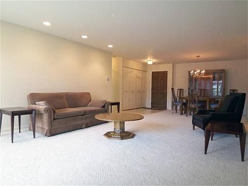 Living room features accent recessed lighting and opens to foyer entry with big guest closet.