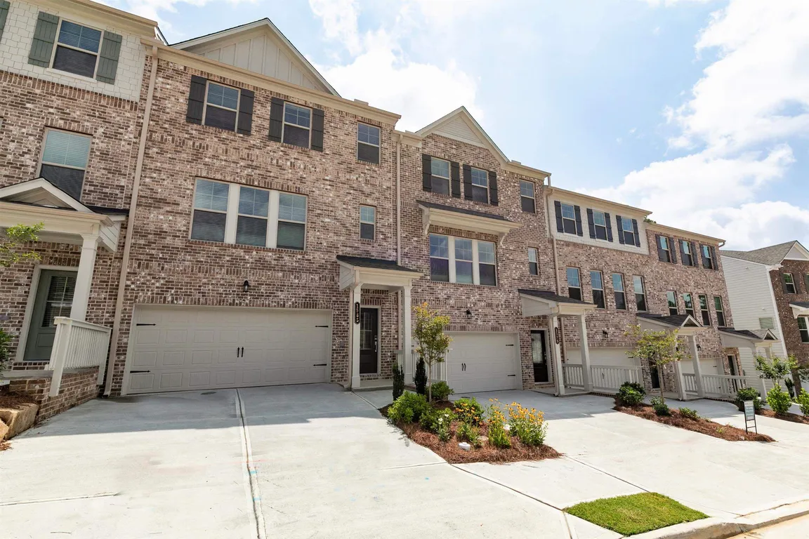 Exterior shot of the Kingston floor plan, a three-story townhome with a private driveway and attached garage.