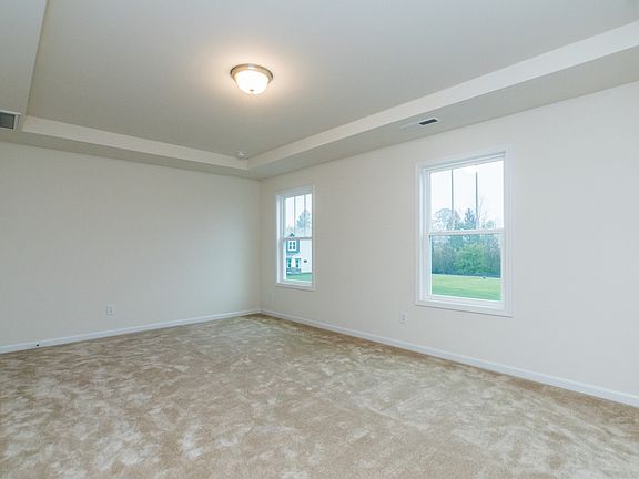 The primary suite offers large windows and a walk-in closet.