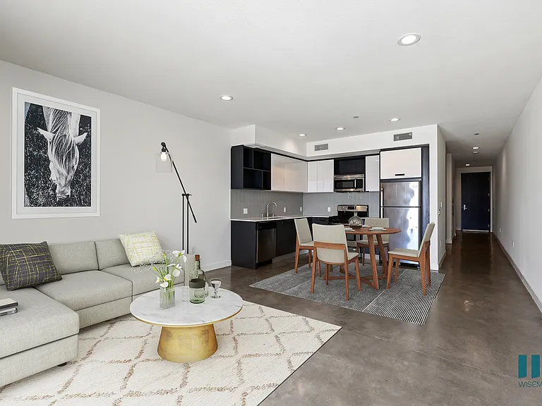 Open-Concept Kitchen, Dining, and Living Room Space with Concrete Flooring
