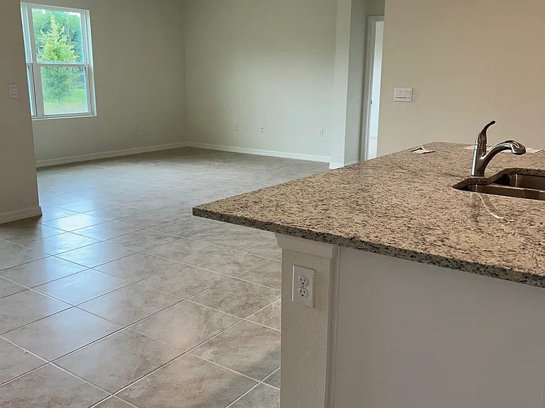Spacious living room with views of peaceful backyard area. Smart home technology panel included to control temperature & smart outlets.