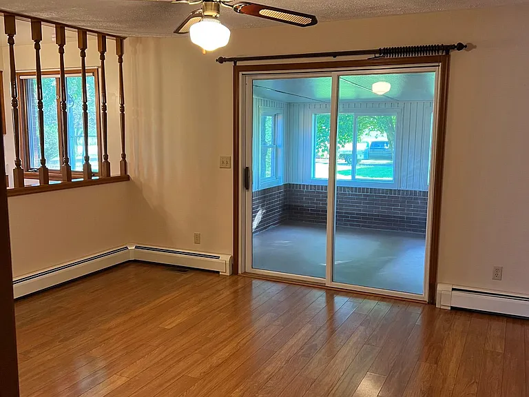 Family room.
Eat in area to left behind spindles. 
Sliding door entry to the sun room
Ceiling fan
FR 15'2" x 12'11"