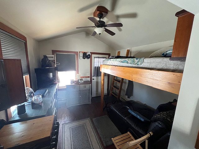 High ceilings main room, view towards front door, ceiling fan, upper bunk bed with custom ladder in right corner of picture.