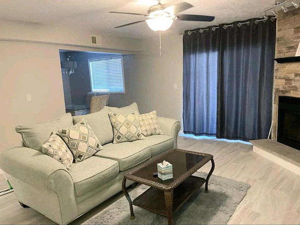 Living room with ceiling fan and room darkening curtains. Sliding door to patio.