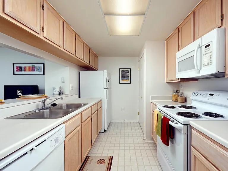 Classic Package I kitchen with white countertops, oak cabinetry, and white appliances