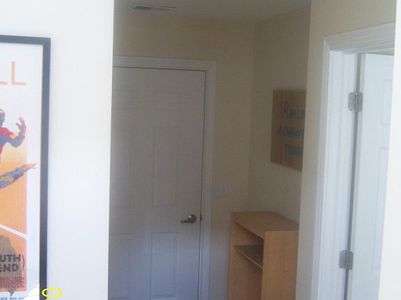 1st floor / bottom level hallway - door leading to garage in back of photo; ensuite 1st floor bedroom is on the right. Foyer stairs on left.