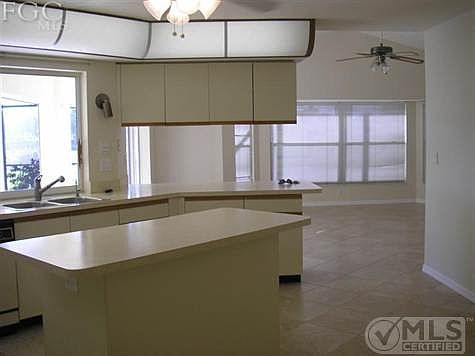 Kitchen with large sliding pass thru window out to lanai and pool area