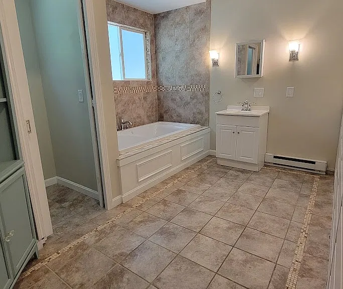 Jetted tub and pocket door water closet in master bath.