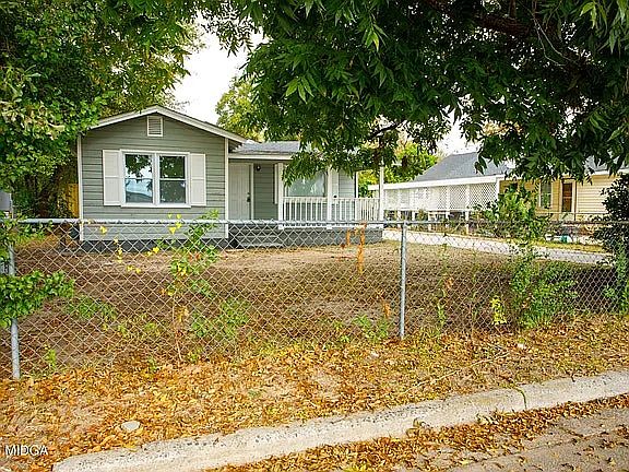 Single-family home with a spacious front yard, mature trees, and a quiet residential setting.