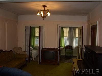 Living room with french doors to front porch in first floor apartment. 