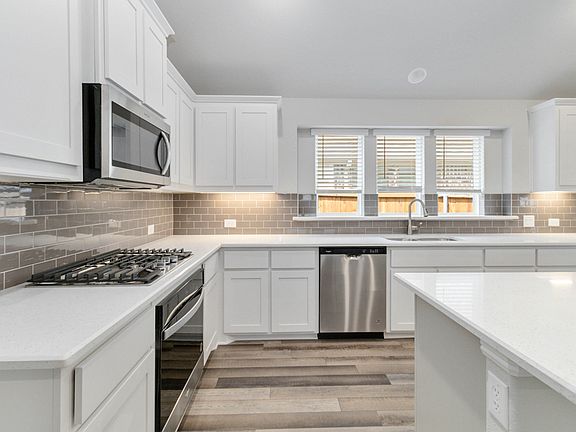 McKinney floor plan featuring open-concept living, three bedrooms, two bathrooms, and a covered pati