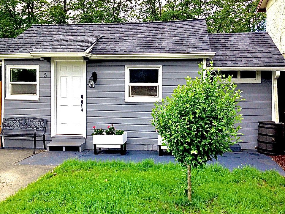 Exterior of Tiny House #5, with green space and flower planters