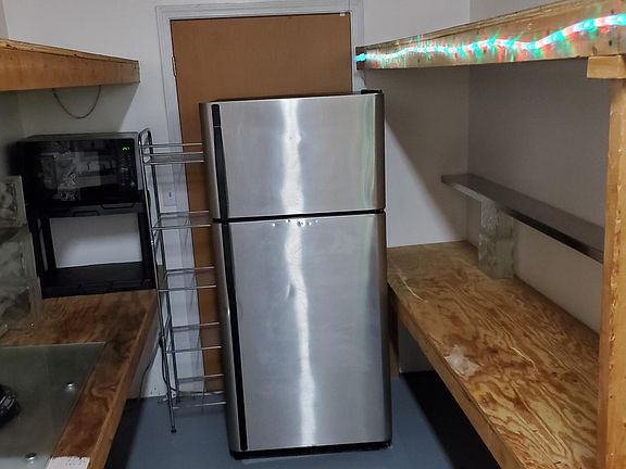 Kitchen area has shelving but no cabinets. It has shelving on both sides, a refrigerator, sinks, hotplate and microwave. Totally functional but without cabinets. It does however have a pantry. If this kitchen was complete I would be asking quite a bit mor