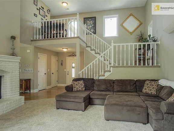 Great Room looking back at front door with wood-burning fireplace on left.