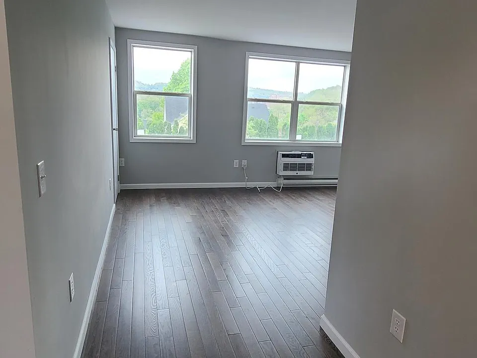 View of spacious oversized living room, new hardwood floors throughout with new efficient smart air conditioners