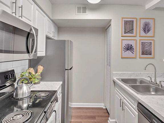 Our floor plans showcase galley-style kitchens with modern, pristine white cabinetry and stainless-steel appliances, creating a kitchen of grace and practicality.
