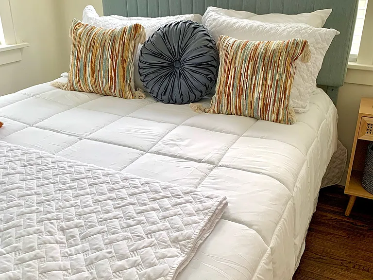 Large bedroom with blinds on all windows and high efficiency, ultra quiet window unit.