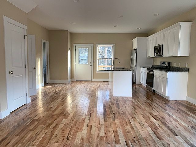 Hardwood floors, storage closet, washer & dryer, half bath, south-facing windows to back deck, bar countertop island, dishwasher, gas range & oven, microwave.