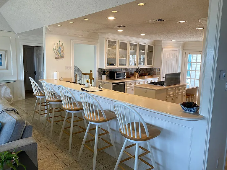 Kitchen Countertop with bar stools and kitchen in background