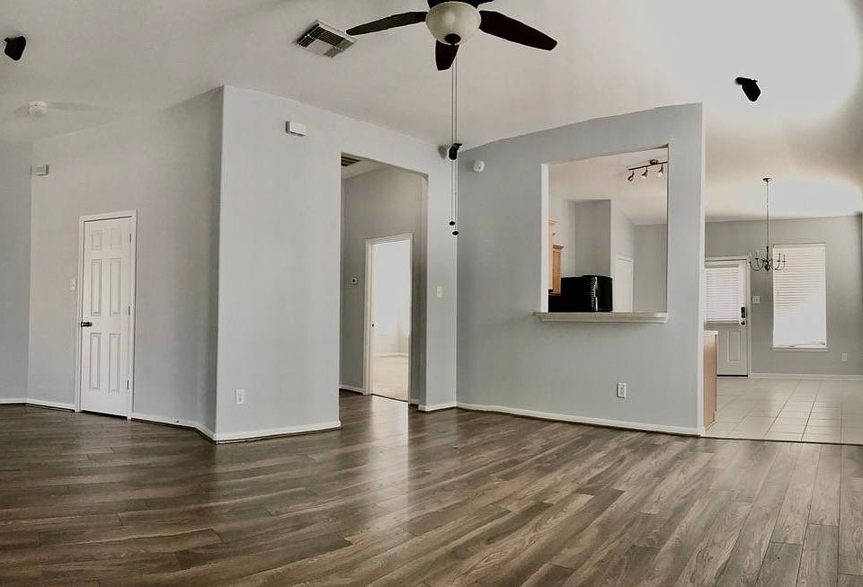 Large living area with open floor plan, surround sound speakers, new floors and new, trendy, light gray paint.