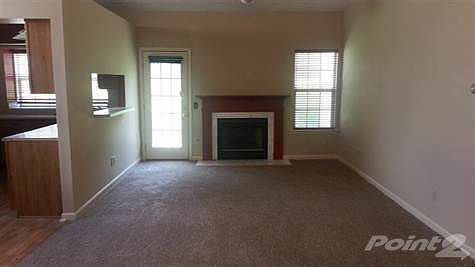 Family room with fireplace, new carpet, fresh paint, and vaulted ceilings.