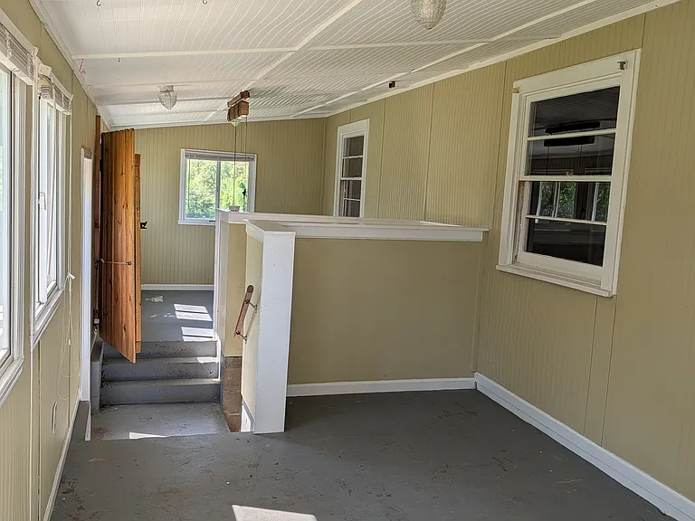 full view of sunroom, basement steps in middle