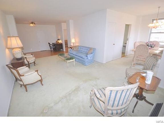 Large sunny living room opens to the "L" shaped dining room and has a door leading to the private Balcony .  The living room also opens to the entry foyer that can be used as a home office area or dining area.  The living room has covered parquet floors a