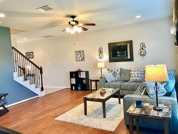 Notice the spacious living area and the stairs with the wrought iron rail.