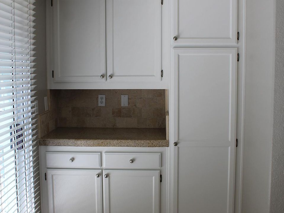 Breakfast nook on second level is adjacent to kitchen with plenty of cabinets; sliding glass door to deck on left