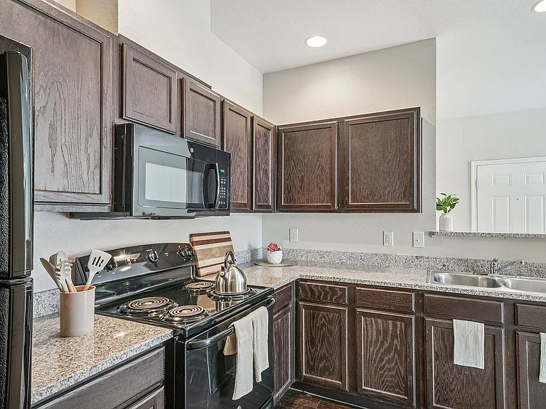 This bright kitchen at Walnut Grove apartments features granite countertops and natural light.