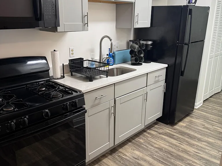 Streamlined kitchen with ample shaker cabinetry, generous counter space, and full-size appliances for everyday cooking.