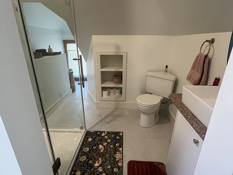 Brand new 3/4 bathroom with luxurious tile and built in shelving.