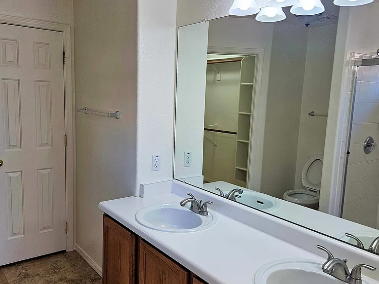 Primary bath with double sinks and linen closet.