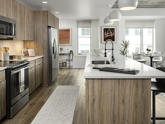 Apartment Kitchen with Stainless Steel Appliances, Dining Room and with wood floors.