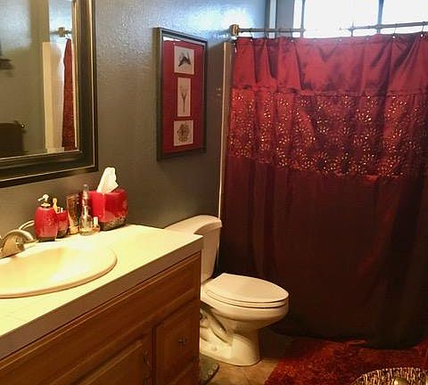 Full bath includes tiled bathtub/shower and full-sized vanity with storage below.