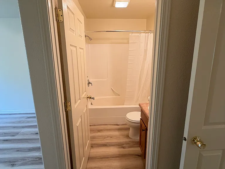 Master bathroom with curved shower curtain rod for more elbow room.