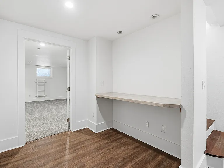 Basement built-in desk outside primary basement bedroom