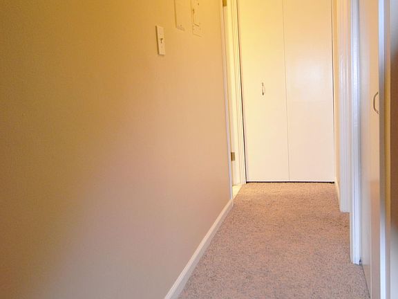 hallway to bedroom on right and bathroom on left