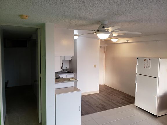 Kitchen area, the kitchen floor was just put in, so the refrigerator is out of place. You can reset the refrigerator to a few different locations, depending on how you want the layout. Door on the left is to mauka bedroom & bathroom.