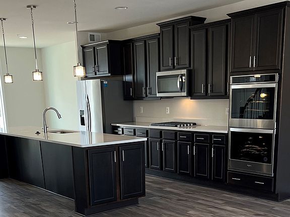 Island kitchen with dark cabinets in a DRB Homes Grable II plan at the WestRidge community.