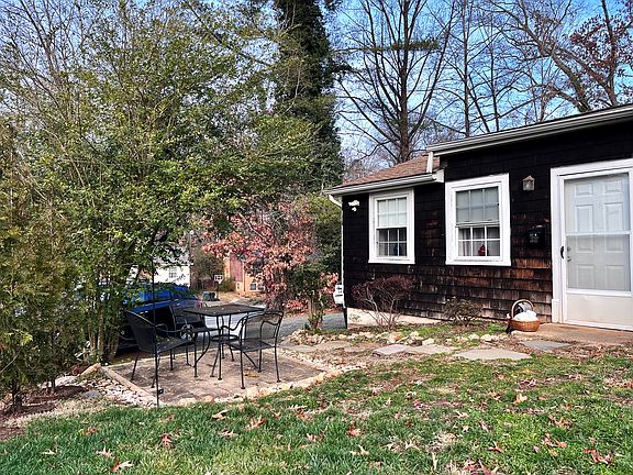 Front of cottage with small patio and yard.