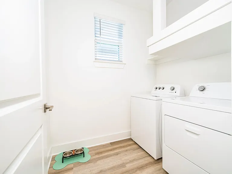 A dedicated laundry room with full-size appliances and added storage keeps daily tasks organized and conveniently tucked away.