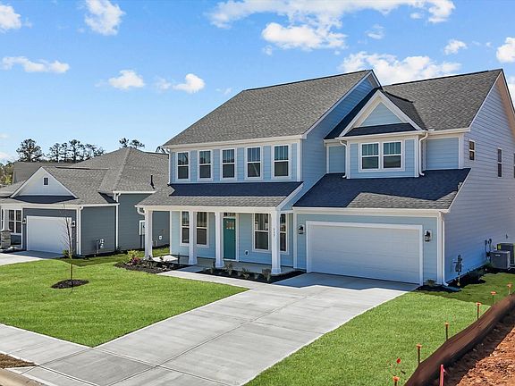 Light blue exterior two story home with centered front door and two car garage at Wells Crossing by