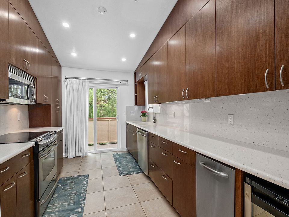 Galley-style kitchen with soft-close drawers, stainless appliances, and refrigerator included.